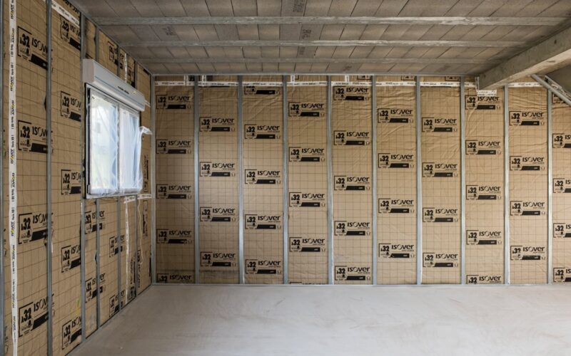 Isolation thermique intérieure (ITI) – pose de laine minérale entre montants métalliques sur mur intérieur maison en Isère